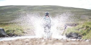 female mountain biker riding through water