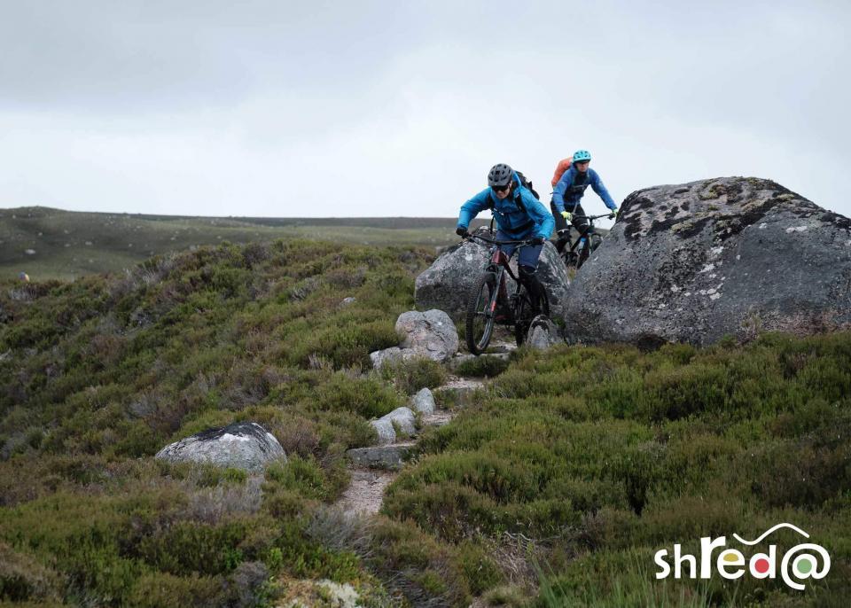 female mountain bikers riding through rocks