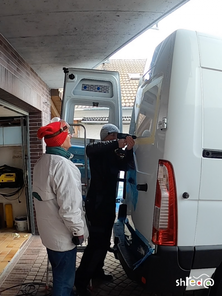 drilling holes into the van for the rear windows